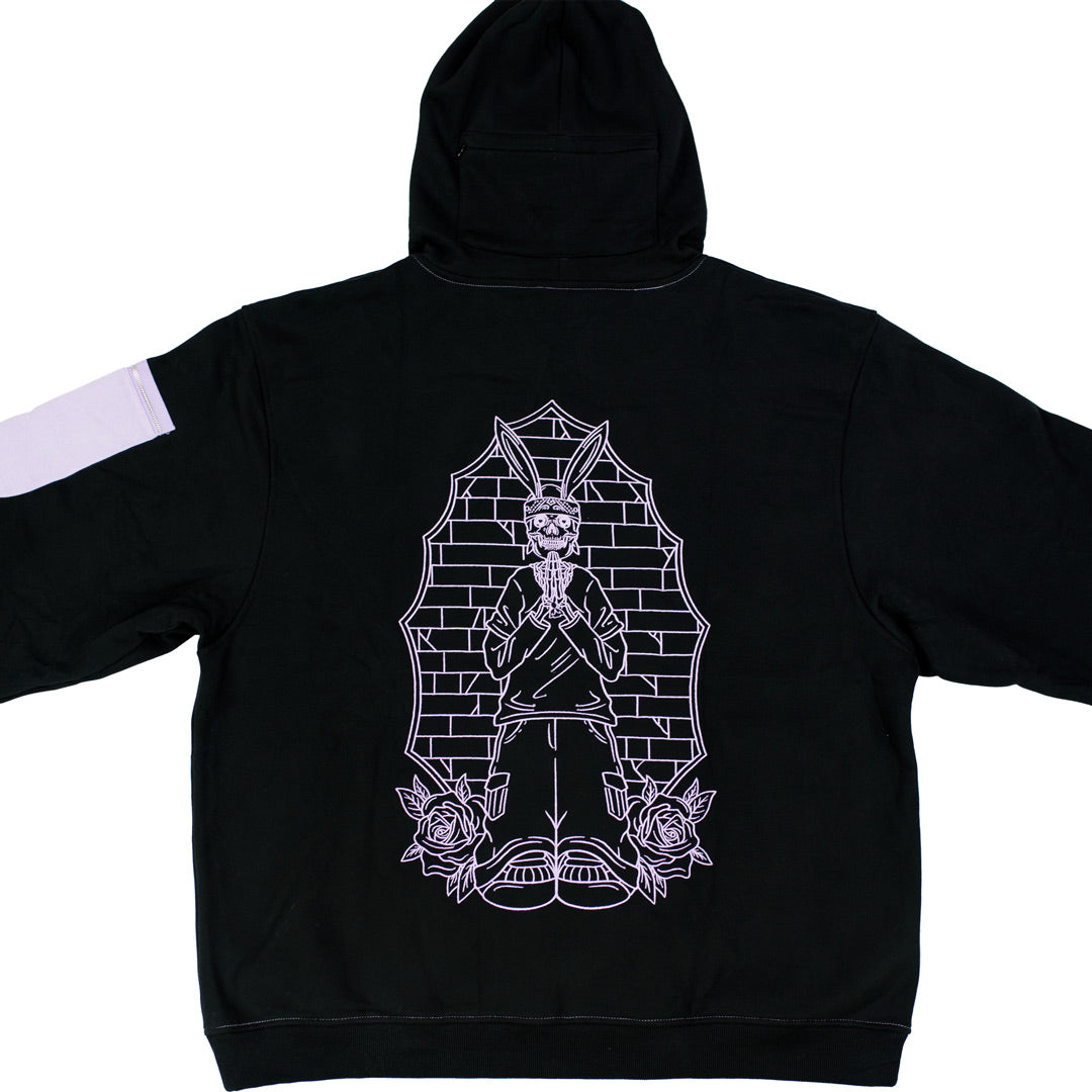 back view of black hoodie with a lavender embroidered praying rabbit design. there is a hidden zipper pocket behind the hood