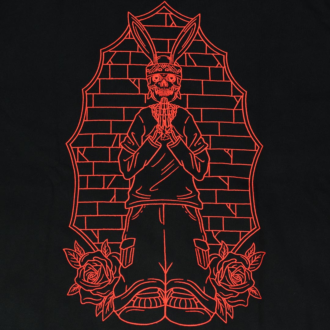 red embroidered design of a praying rabbit