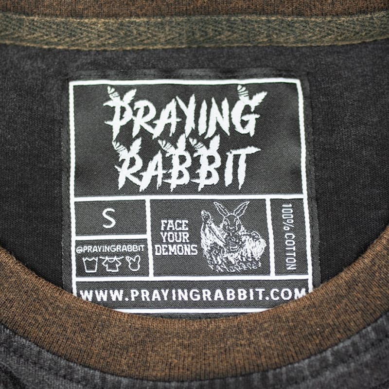 praying rabbit woven label that reads face your demons