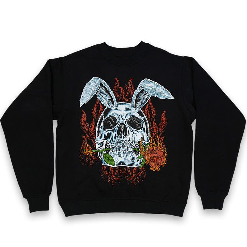 Black crew neck sweater with a printed graphic design of a rabbit skull biting a red rose with flames in the background