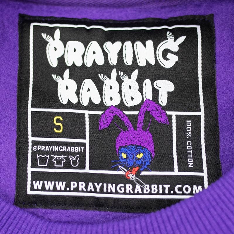inside woven label that shows the cat with bunny ears holding a tongue in its mouth