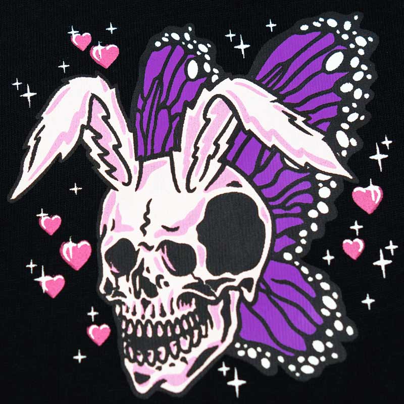 close up of a rabbit skull with butterfly wings and little pink hearts around it.