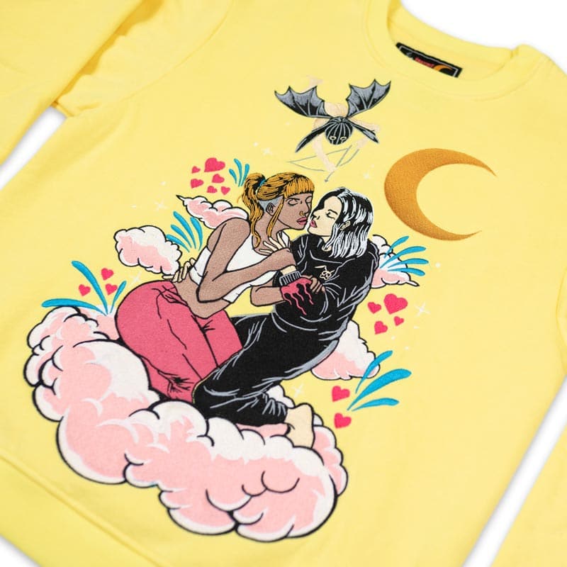 embroidered crew neck that shows two girls hugging each other on a pink cloud. above them is a rabbit cupid shooting an arrow at them and the crescent moon is behind them