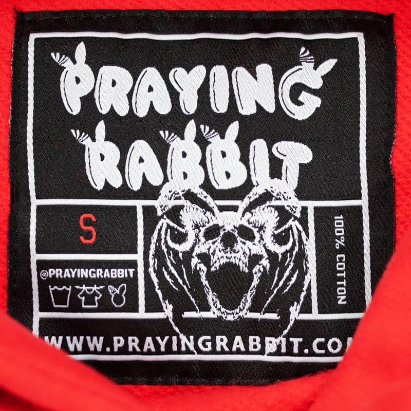 inside woven label that reads praying rabbit and shows demon rabbit skull with bat wings and horn