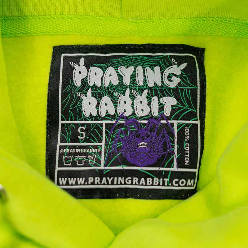 woven label that reads praying rabbit and has purple rabbit skeleton spider