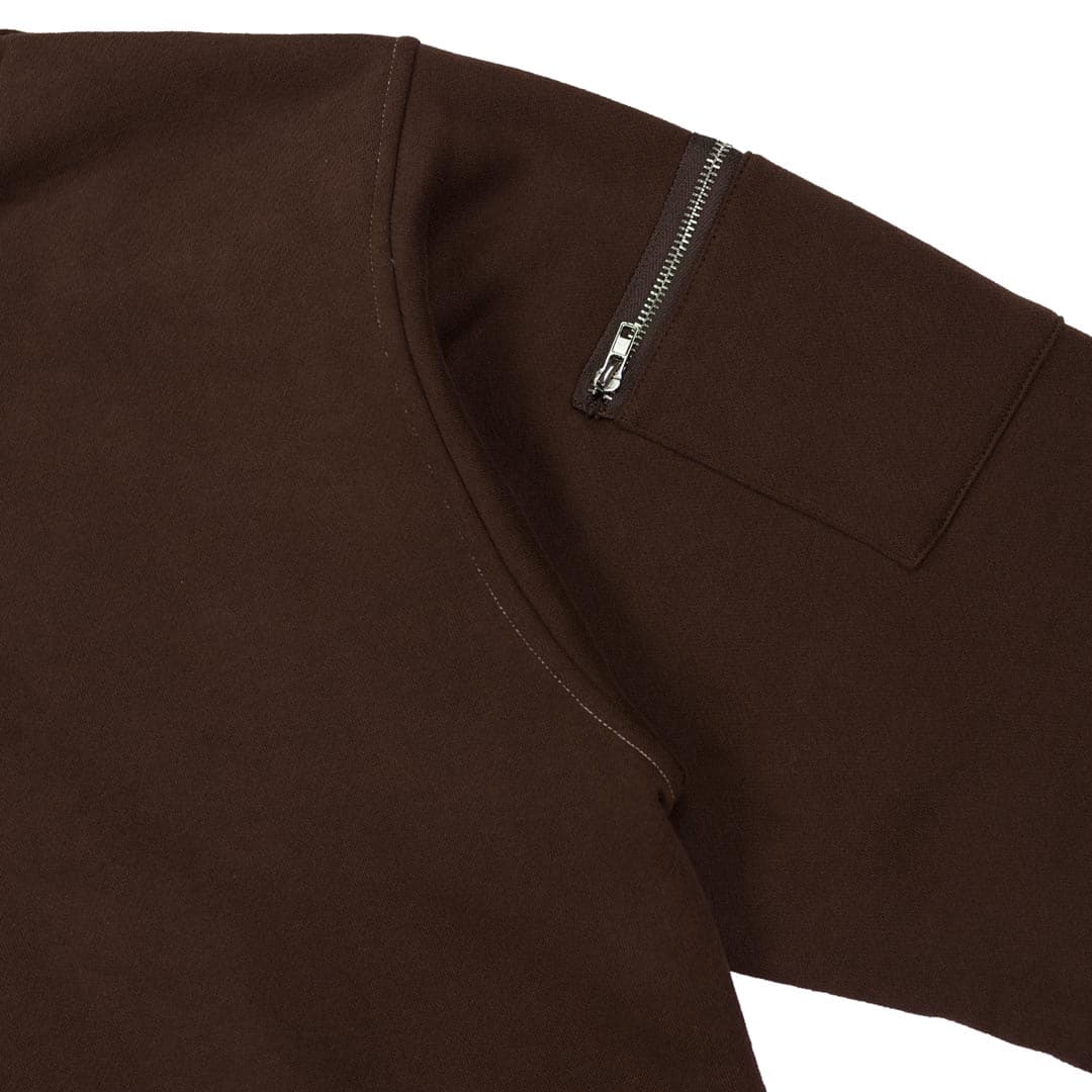 close up of zipper pocket on left sleeve of brown hoodie