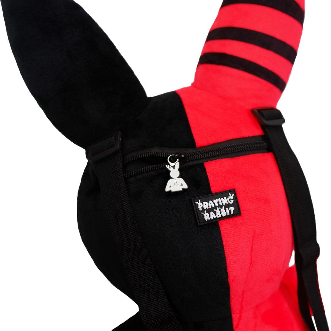 back head of the rabbit backpack which shows a close up of the praying rabbit rubber logo zipper